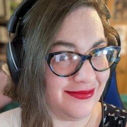 Kareesh with bright red lipstick, glasses, and a headset.